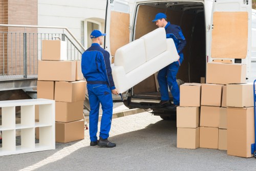Worker wearing PPE while carrying furniture safely