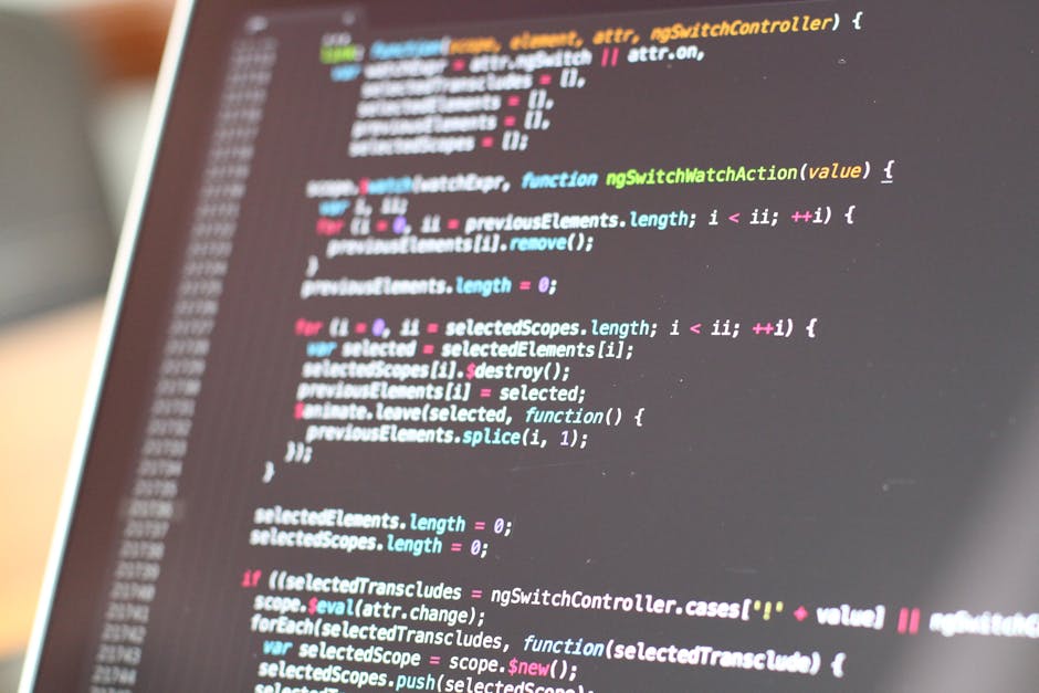 Photograph of a computer screen displaying lines of code written in JavaScript language, with syntax highlighting in various colors including green, pink, blue, and yellow. The code appears to be part